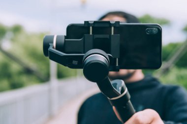 Doğadaki blogcu, el kamerasıyla akıllı telefondan video çekiyor.