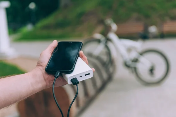 Bisikletin arka planında taşınabilir şarj aleti. Powerbank telefonu şarj ediyor
