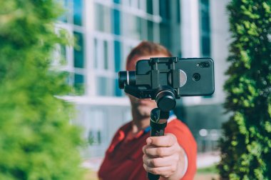 Şehirdeki blogcu, manuel kamera dengeleyicisiyle akıllı telefondan video çekiyor