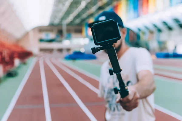 Blogger in the stadium shoots video with action camera