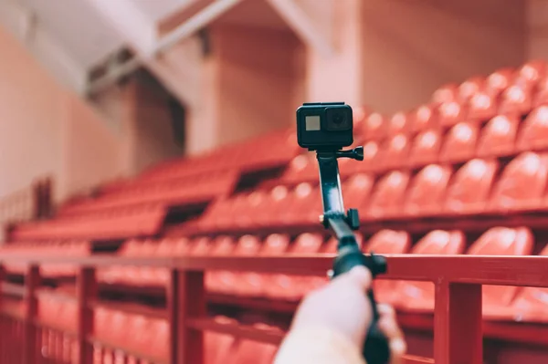 Blogger in the stadium shoots video with action camera