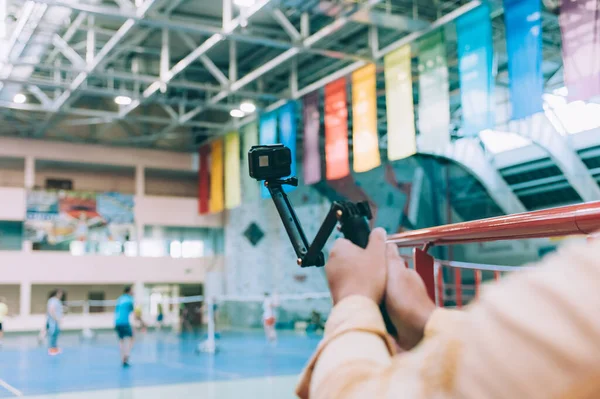 Blogger in the stadium shoots video with action camera