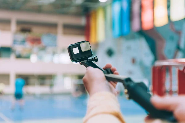 Blogger in the stadium shoots video with action camera