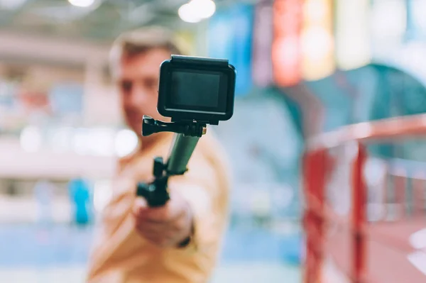 Blogger in the stadium shoots video with action camera
