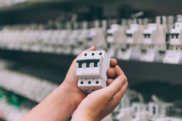 Adam elinde elektrik kablolarının anahtarlarını tutuyor. Kavram adamı bir mağazadan ürün seçer.