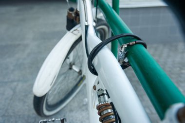 Beyaz bisiklet korkuluğa bağlı. Güvenlik ve hırsızlıkla mücadele konsepti