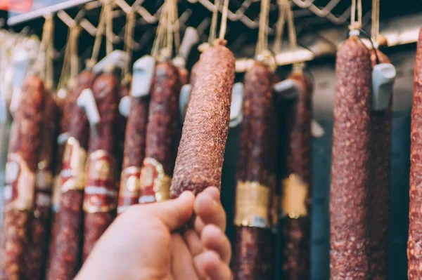 Süpermarkette bir adam dükkanın vitrininde sosis topluyor.