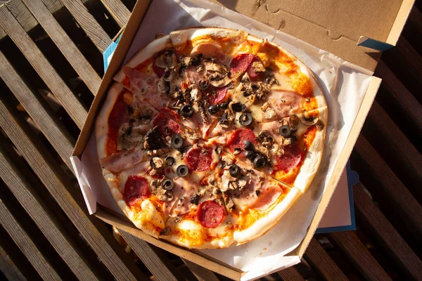 Pizza in a box close up. Fast food in the fresh air