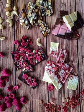 Tahta arka planda böğürtlen ve fındıklı gerçek Belçika el yapımı çikolata.