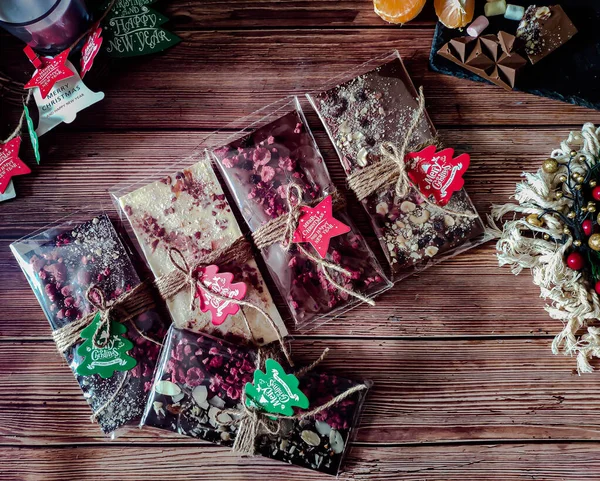 gift set of Real Belgian handmade chocolate with berries, nuts and natural dyes on a wooden background   in a Christmas style