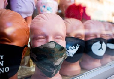 Bir vitrindeki bir mankenin üzerindeki virüs koruma maskelerinin farklı türleri.