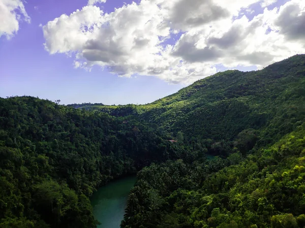 Kalın yeşil tepelerin arasında bir dağ nehri.