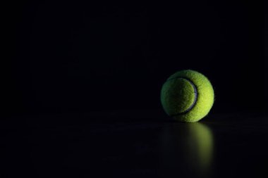 Tenis topu koyu arkaplanda koyu ışıkta izole edildi
