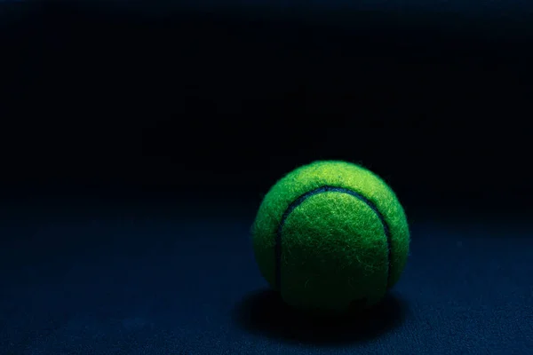 Tenis topu koyu arkaplanda koyu ışıkta izole edildi