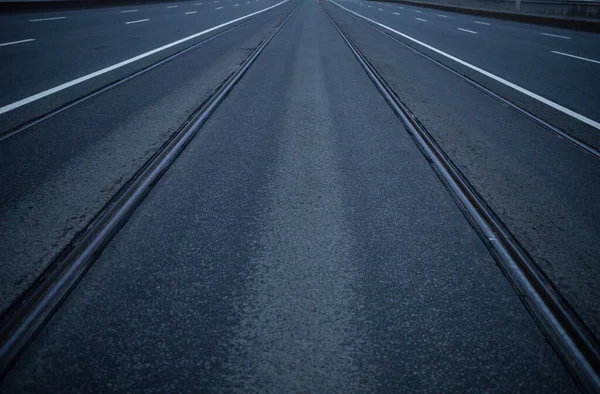 Ufkun ötesine uzanan rayları olan simetrik bir yol.