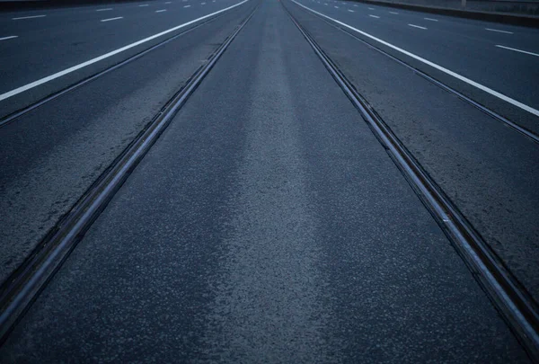 Ufkun ötesine uzanan rayları olan simetrik bir yol.