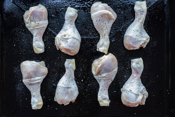 Salamurada birkaç parça çiğ tavuk bacağı ıslak bir çarşafın üzerinde yatar ve hazır olmayı bekler.