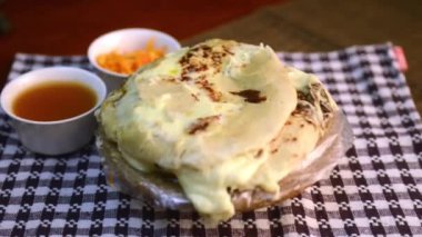 Pupusas çanağı ahşap bir masaya kumaşla vuruyor.