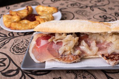 Jambonlu biftek ve soğanlı İspanyol ekmekli sandviç.