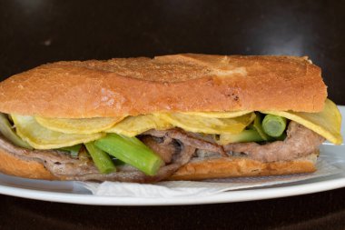 Kızarmış patates ve yeşil sarımsaklı at etli sandviç.