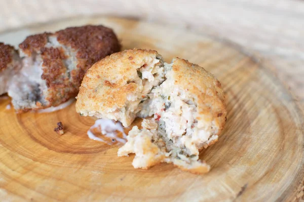 Deux Croquettes Différentes Ouvertes Sur Une Assiette Bois Image En Vente