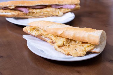 Beyaz bir tabakta omlet ve baget.