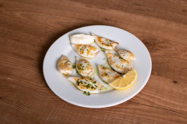 Sarımsak ve maydanoz soslu mürekkepbalığı yumurtası.