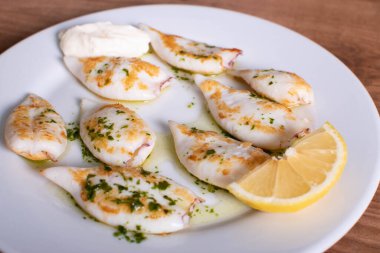 Sarımsak ve maydanoz soslu mürekkepbalığı yumurtası.