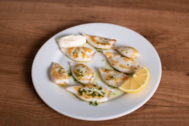 Sarımsak ve maydanoz soslu mürekkepbalığı yumurtası.