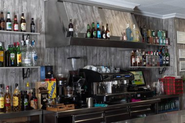 Kahve makinesinin yanında şişe olan bir bar.