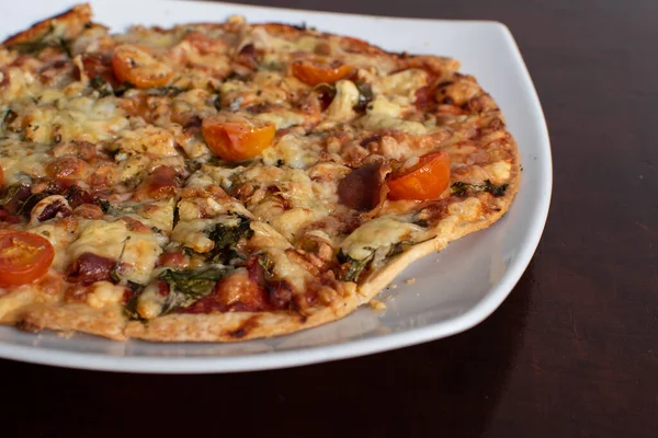 homemade vegetables pizza with cherries on a plate