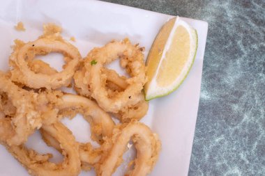 Tempura ve limonla harmanlanmış bir tabak kalamar.