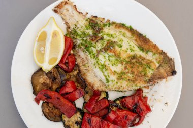 Sebze ve limonla karışık levrek tabağı.