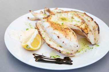 İnce dilimlenmiş mayonez ve limonlu mürekkep balığı.