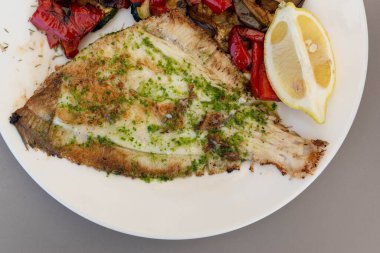 Sebze ve limonla karışık levrek tabağı.