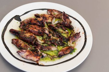 Bir tabak taze ızgara kalamar ve sos.