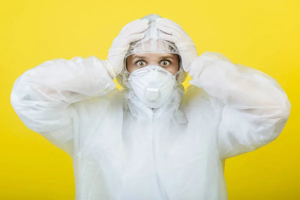 Shocked doctor in protective suit respirator masks isolated on yellow a background studio. Epidemic pandemic 2019 fast-spreading coronavirus 2019 NSA originating in Wuhan, China virus