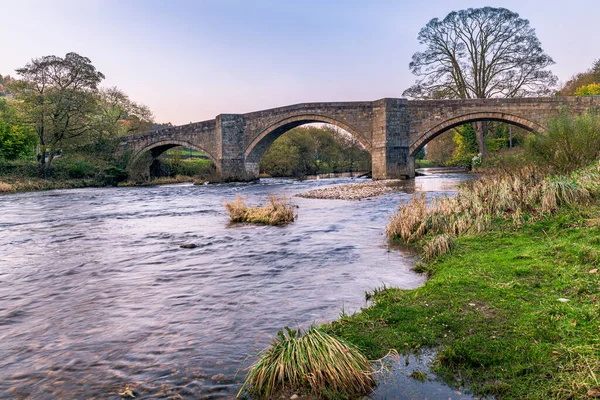 Barden Bridge is a three-arched humpbacked bridge across the River Wharfe north of Bolton Abbey.