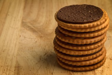 Tahta arka planda çikolata dolu bir bisküvi kulesi