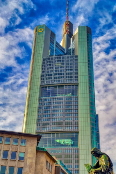FRANKFURT AM MAIN, GERMANY, 15 Şubat 2020: Frankfurt am Main, Almanya şehir merkezinde eski ve bronz bir heykelin üzerinde yükselen yüksek ve modern bir iş binası.