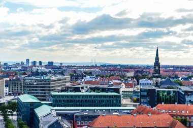COPENHAGEN, DENMARK, 10 Ekim 2015: Kopenhag binaları ve çatıları üzerine panoramik manzara. Kopenhag üzerinde panoramik manzara ve arka planda Oresund Boğazı üzerinde ünlü Öresund Köprüsü silueti.
