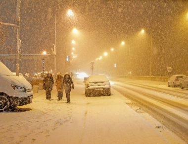 BANJA LUKA, BOSNIA VE HERZEGOVINA, 19 Şubat 2018: Bosna-Hersek 'in Banjaluka kentinde akşam kar fırtınası sırasında sokaklar, arabalar ve kentteki insanlar.