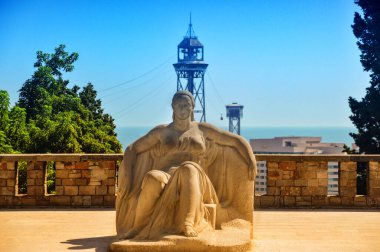 BARCELONA, SPAIN, 21 Ağustos 2017: Montjuic tepesinde Barcelona, İspanya 'da arka planda Port Fell Aerial Tramvay ile birlikte bir kadın heykeli.