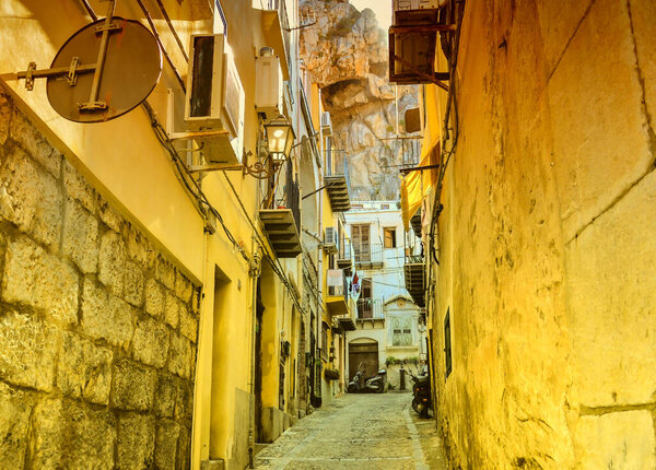 CEFALU, SICILY, ITALY, August 13 2015: Old street under the rock in Cefalu, Italy.