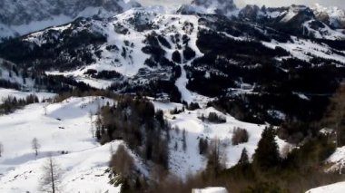 Avusturya 'nın Nassfeld kentindeki bulutlu kış gününde arka planda yamaçları ve dağ tepeleri olan Nassfeld kayak merkezinin manzarası.