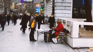 SARAJEVO, BOSNIA VE HERZEGOVINA, 26 Şubat 2019: Gazeteci Saraybosna, Bosna-Hersek şehir merkezinde diğer insanlar geçerken bir arkadaşıyla konuşuyor.