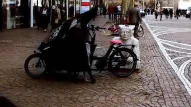 FRANKFURT AM MAIN, GERMANY, 22 Mart 2019: Bir bayan park halindeki Urban Arrow elektrikli kargo bisikletinden kişisel çantasını alıyor ve Frankfurt am Main, Almanya 'ya gidiyor.