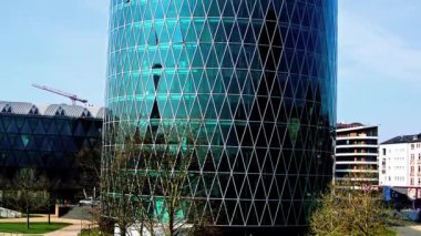 FRANKFURT AM MAIN, GERMANY: 23 Mart 2019: Frankfurt am Main, Almanya 'daki yeşil camdan modern yuvarlak ofis binası.