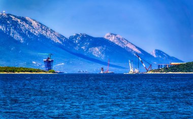 NEUM, BOSNIA VE HERZEGOVINA, Temmuz 03: 2020: Hırvatistan ile Peljesac adasının yarısını birbirine bağlayacak yeni köprünün şantiyesine bakmak üzere Neum körfezi üzerindeki hava manzarası.