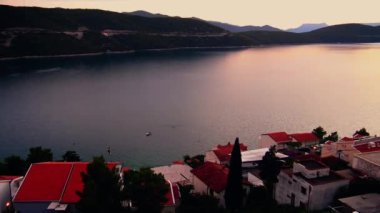 Bosna-Hersek 'in Neum kentinde sıcak yaz gününün sonunda, akşam karanlığında deniz koyunun üzerindeki manzara.